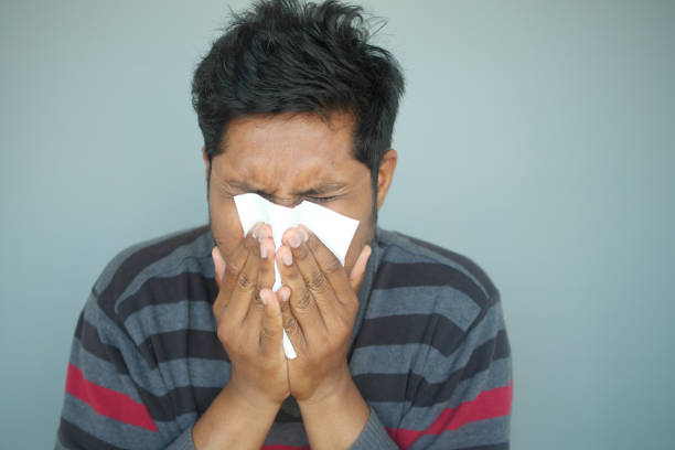 Sick man with flu blow nose with napkin