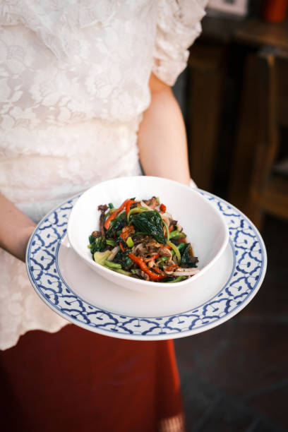 istock Thai-style stir-fried hot basil dish served in a traditional patterned bowl, Featuring fresh vegetables, Aromatic herbs and bold spices, Capturing the authentic flavors of Thai cuisine 2194478693
