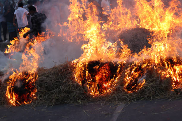Mysuru, Karnataka, India-January 14 2025; Flames from the Fire of haystack lit for the Bull run sport during Makar Sankranti religious festival in Mysore, India.