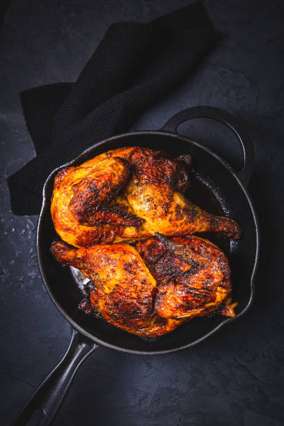 istock Delicious grilled chicken in iron pan on black background 2194483753