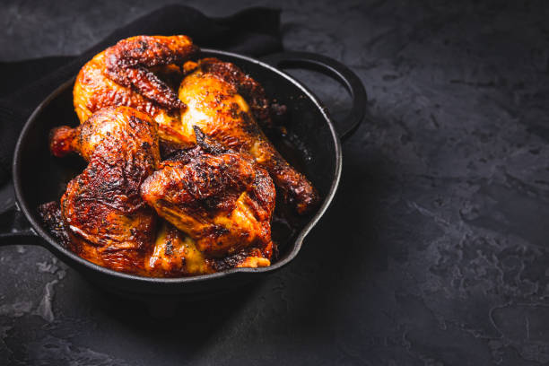 istock Delicious grilled chicken in iron pan on black background 2194483754