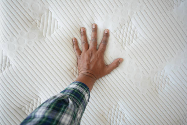 istock Hand touching and pressing orthopedic mattress on bed. 2194484559