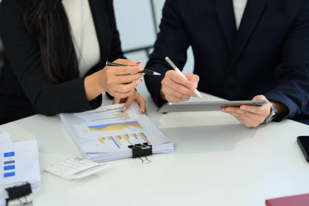 istock Professionals businesspeople reviewing documents and data on digital tablet 2194485249