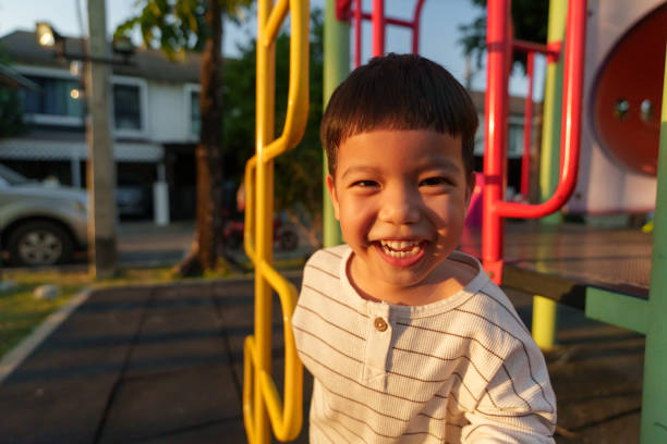 istock Young Asian Boy Enjoys Playtime at Vibrant Playground During Sunset 2194491033