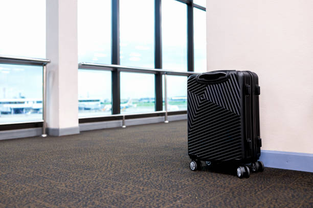 Closeup of woman hand pulling black luggage isolated on white background. Concept, suitcases or traveling bags. Main items for loading things or personal stuff , when go travelling. Easy to carry.