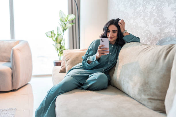 Young Arabic Woman Relaxing with Smartphone in Modern Home