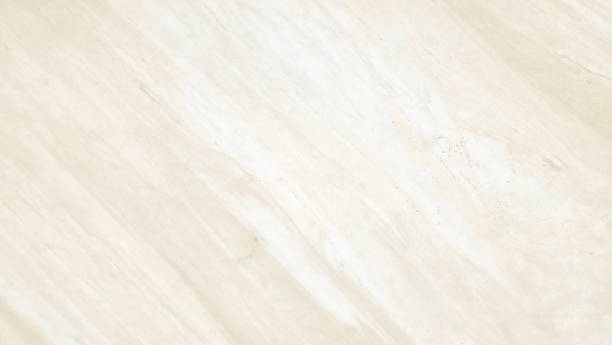smooth white, gold or cream marble stone surface with subtle, delicate veins creating a flowing pattern across the frame, offering a luxurious and elegant backdrop.