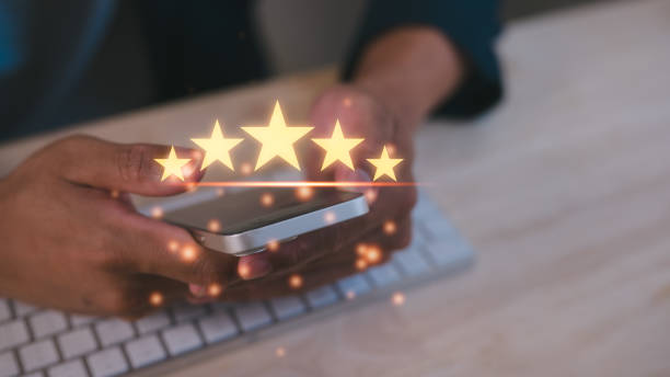 istock Customer service experience and satisfaction survey concept Close up of man customer sitting in office or cafe workspaces giving a five star rating on smartphone. Review, Service rating, satisfaction 2194498355