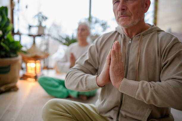 istock Elderly couple is doing yoga together. Home meditations. 2194499147