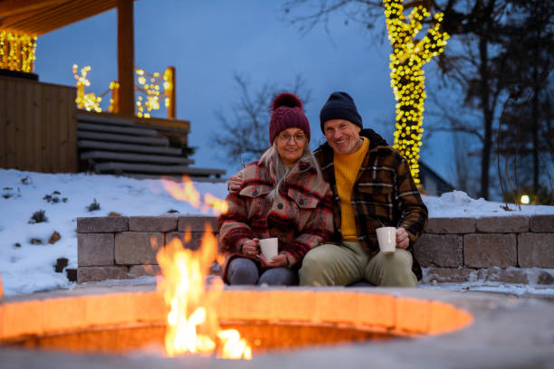 istock Older couple has lit a fire in garden fire pit. Seniors watching flames, relaxing and drinking hot tea. 2194499252