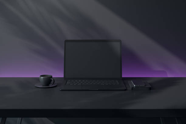 istock Modern laptop with blank screen on a black desk, accompanied by smartphone and coffee cup, dark background with purple gradient lighting. 3D Rendering 2194499495