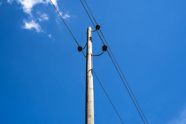 Wooden pole with power lines in blue sky