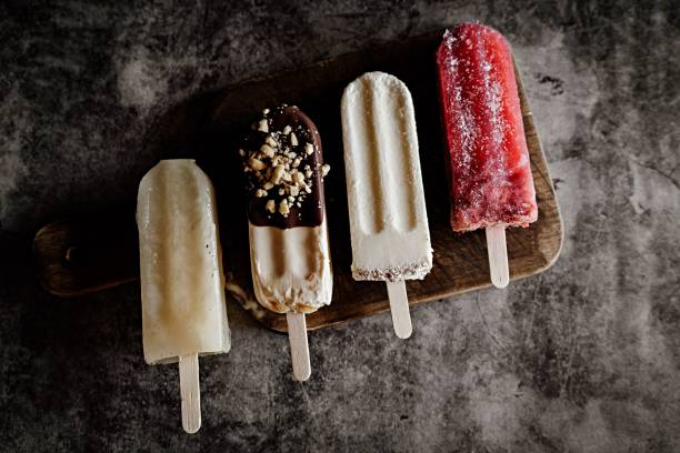 istock Assorted popsicles on a wooden board with a dark textured background 2194503034