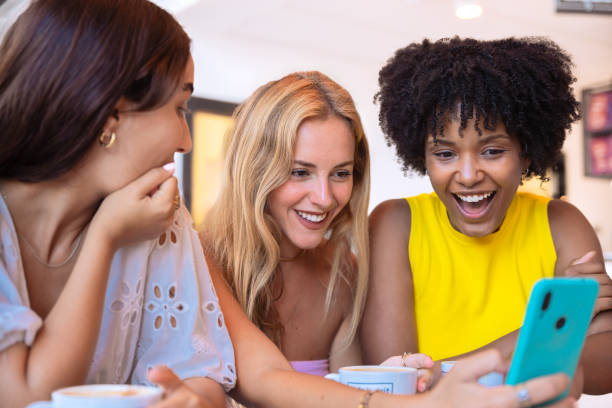 istock Three Women Socializing with Smartphones in a Modern Cafe 2194503294