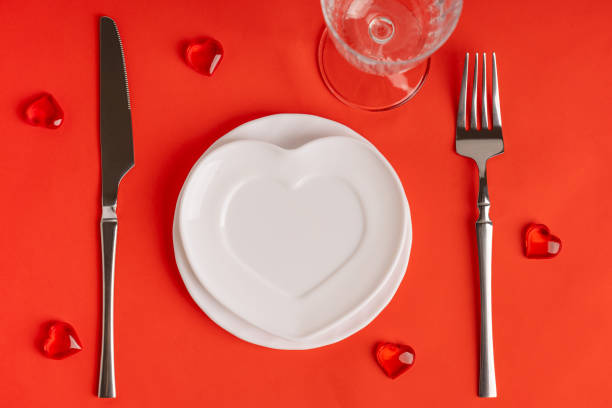 istock Overhead view of served red table with heart shaped empty plate, glass, fork and knife for valentines day 2194507314
