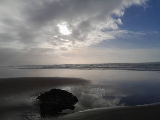 istock A Cloudy Beach With The Silhouette Of A Rock 2194508337