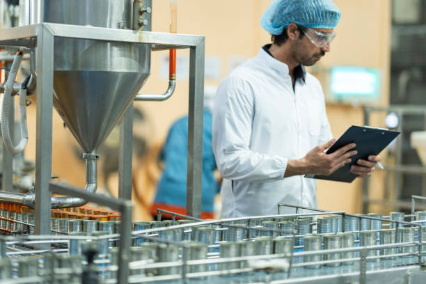 istock Inspector checking automated machinery in food production facility Focus on quality control safety and workflow efficiency. Worker overseeing food packaging machinery in a modern manufacturing plant. 2194508863