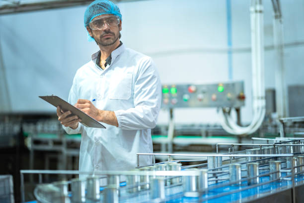 istock Inspector checking automated machinery in food production facility Focus on quality control safety and workflow efficiency. Worker overseeing food packaging machinery in a modern manufacturing plant. 2194509178