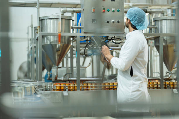 istock Inspector checking automated machinery in food production facility Focus on quality control safety and workflow efficiency. Worker overseeing food packaging machinery in a modern manufacturing plant. 2194509247