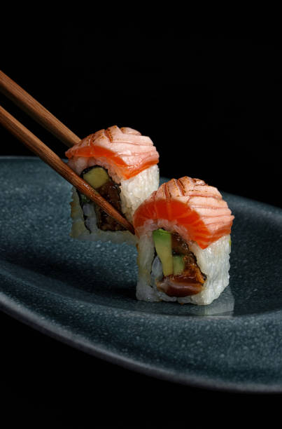 istock Sushi roll with salmon, cucumber, avocado and wasabi on black background 2194514068