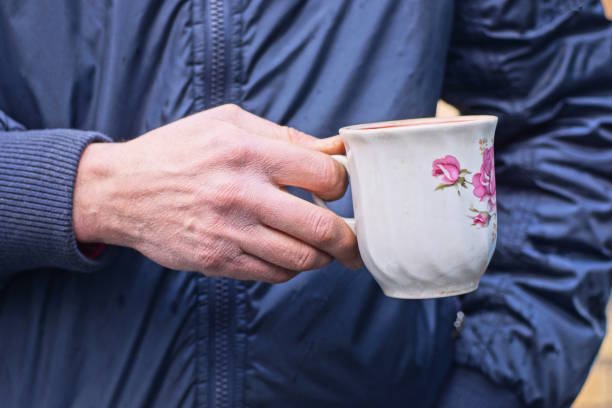 istock hand of a man in black clothes holding a one white ceramic cup 2194517188