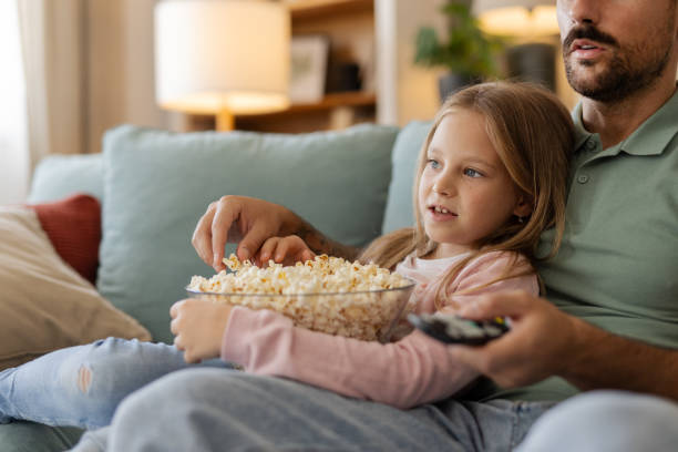 istock Cozy Evening: Dad and Little Girl Watching TV 2194522323