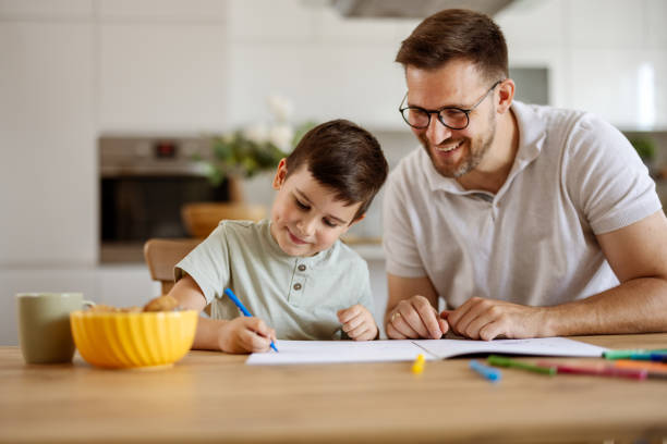 istock Happy Dad and Excited Little Boy Drawing on a Cozy Weekend 2194522418