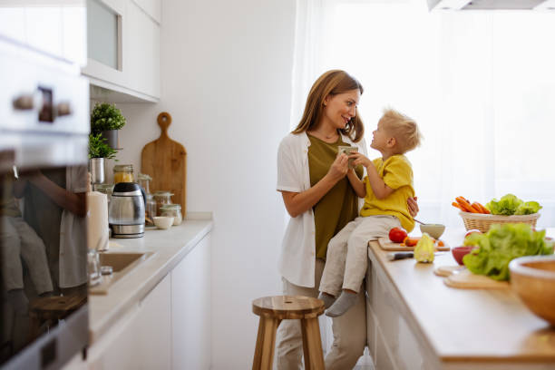 istock Joyful Family Moment: Mom and Her Little Boy Playing in the Kitchen 2194522445