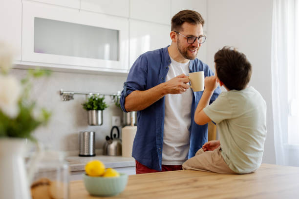 istock Joyful Parenthood: Father and Son Talking and Smiling Together in the Kitchen 2194522537