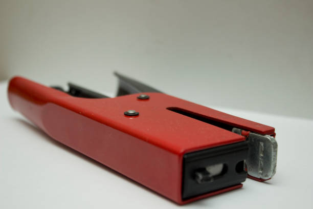 Close-up of a vibrant red stapler on a desk.