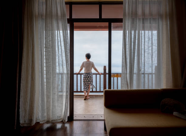 istock Woman on balcony overlooking ocean 2194524009
