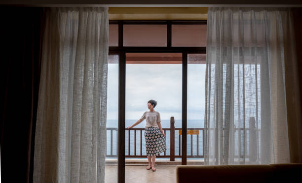 istock Woman on balcony overlooking ocean 2194524051