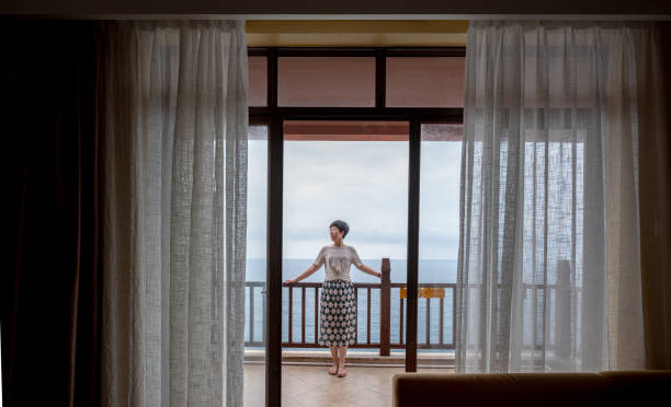 istock Woman on balcony overlooking ocean 2194524058