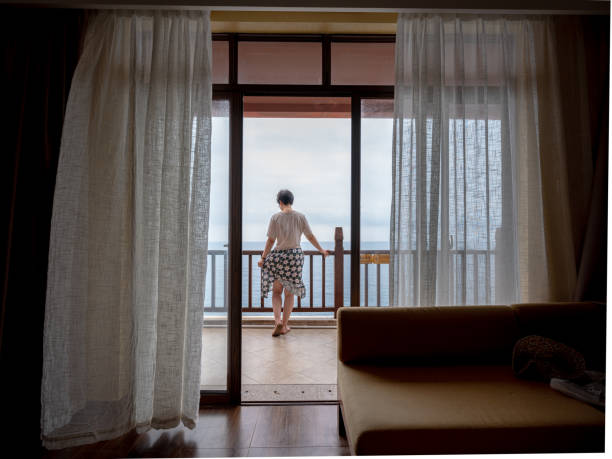 istock Woman on balcony overlooking ocean 2194524212