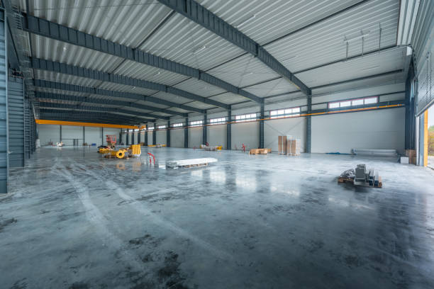 istock Modern Industrial Warehouse With Open Space and Equipment. Spacious, modern industrial warehouse interior with concrete flooring, steel structures, equipmen 2194525835