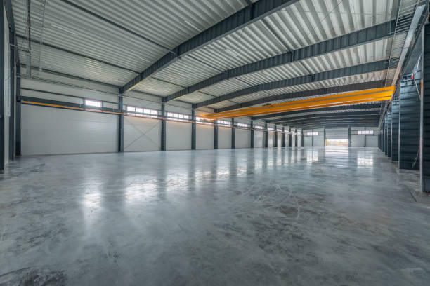 istock Large Industrial Warehouse With Modern Design and Empty Spacious Interior Layout. Yellow Crane In Background 2194525852