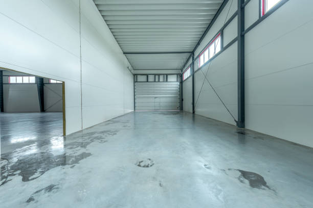 istock Spacious Bright Industrial Warehouse Interior with Concrete Flooring. Bright expansive interior of an industrial warehouse featuring concrete flooring, metal walls, and natural light from high windows 2194525871