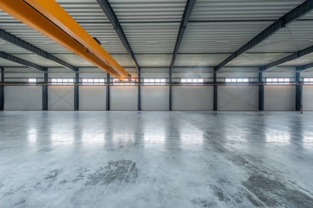 istock Large Industrial Warehouse With Modern Design and Empty Spacious Interior Layout. Yellow Crane In Background 2194525881