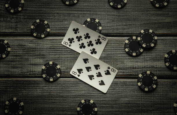 istock A thrilling poker game unfolds on a rustic wooden table, featuring a one pair win combination and various poker chips scattered around, creating a tense atmosphere for the players 2194525993