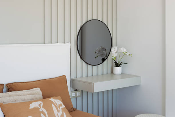 istock Minimalist bedroom design with floating shelf, round mirror, blooming orchid, neutral-toned bedding in warm brown and crisp white, embodying contemporary calm and elegance 2194537109