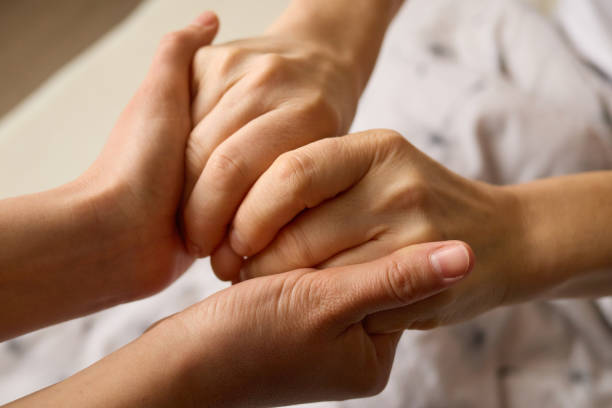 istock Two hands intertwine in a gesture of solidarity, symbolizing support and care. The setting conveys a sense of intimacy and reassurance between individuals 2194541196