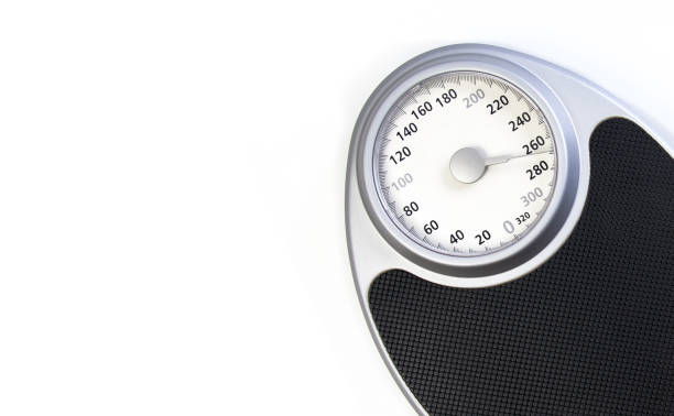 istock Analog weight scale with a black platform and silver frame, placed against a white background 2194541355