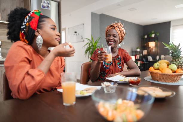 Two smiling black women having breakfast together at home