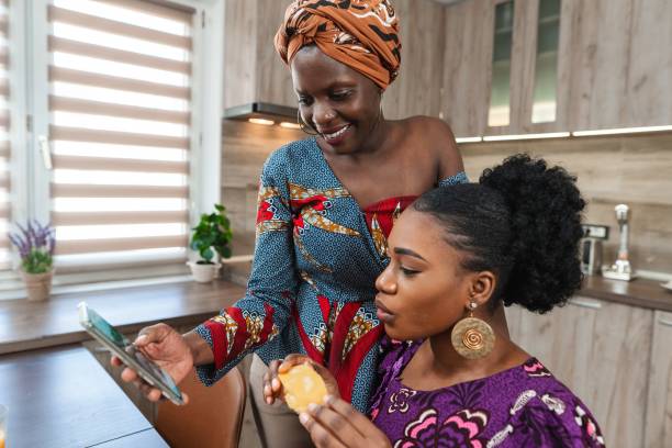 istock Two smiling women sharing a moment and using a smartphone in the kitchen 2194541924