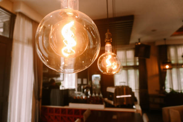 Glowing Edison bulbs create a cozy and inviting atmosphere in a cafe setting.