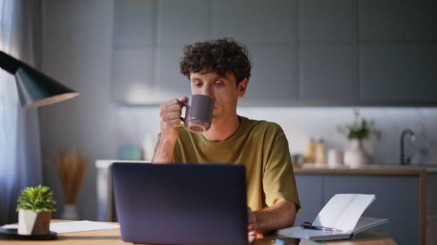 istock Overworked man sipping beverage at workplace closeup. Pensive author drinking 2194544205
