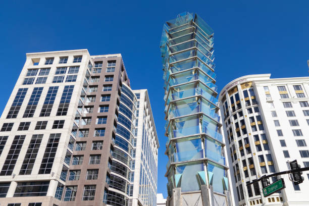 A striking glass and metal sculpture by Artist Wendy Ross stands at the intersection of Orange Avenue and South Street in downtown Orlando, Florida. Framed by modern high-rises, including the historic Grand Bohemian Hotel, this contemporary landmark adds an artistic touch to the bustling cityscape.