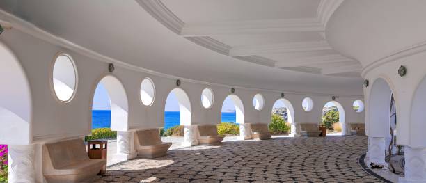 istock Architectural structure with arches and circular windows at Kallithea Springs, Rhodes, Greece. The open side provides sea views and surrounding greenery, with mosaic floors and stone benches. 2194546740