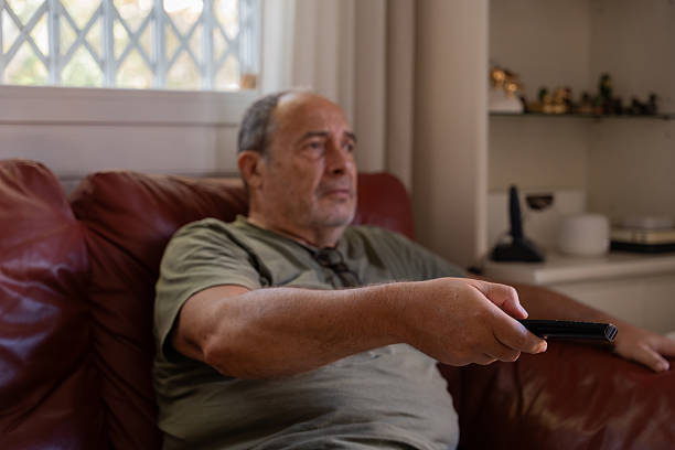 istock Retired man sad and bored watching television at home 2194547068