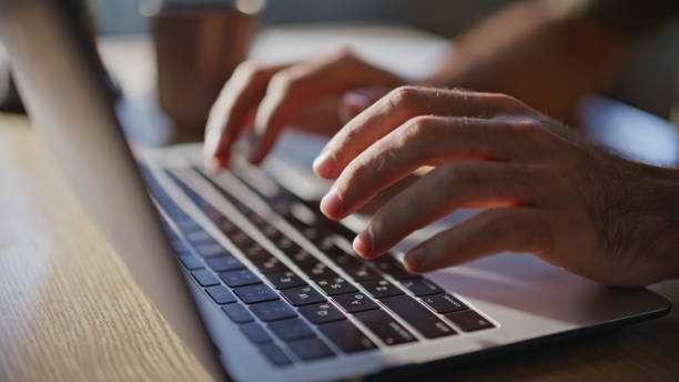 istock Man hands typing keyboard laptop computer in office closeup. Guy fingers working 2194547619